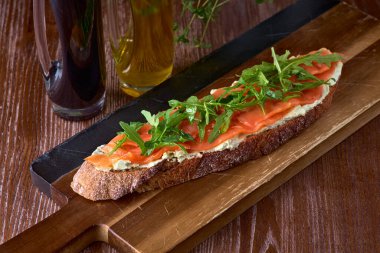 Tuzlu somonlu ekmek tostu, pesto sosu ve krem peynirli ricotta. Atıştırmalık gurme. seçici odak.