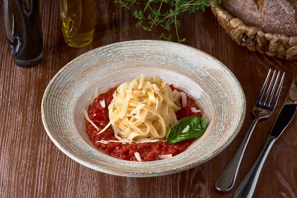 Makaron fettuccine z sosem pomidorowym z dębem Parmesan i bazylia na talerzu, pyszne danie włoskie — Zdjęcie stockowe