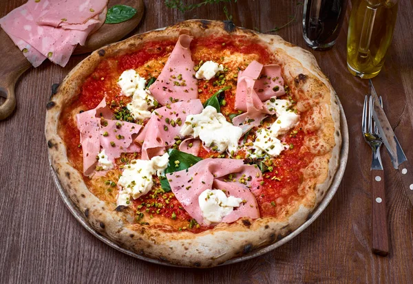 İtalyan pizzası, mortadella ve peynirli, siyah ahşap masa. Sağlıklı yemek..