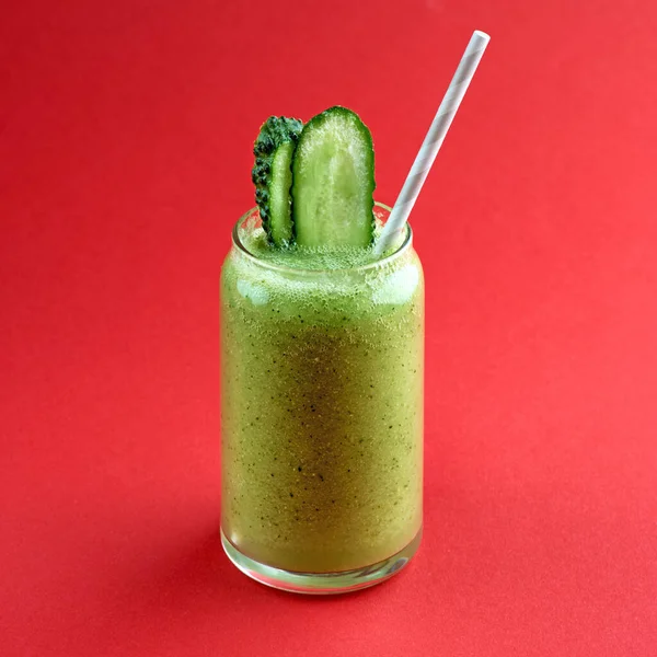 Smoothie vert avec concombre sur fond rouge — Photo