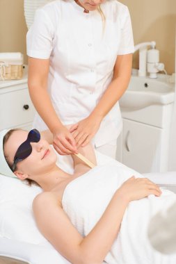 Kollarının altı pürüzsüz. Lazerli saç kesimi olan kadın.