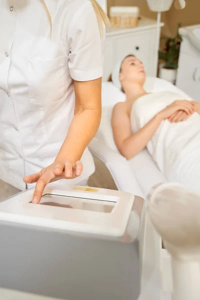 Cosmetologia. Mulher bonita recebendo Laser procedimento de remoção de cabelo no salão de beleza. Closeup de mãos esteticistas fazendo tratamento de beleza para o rosto feminino no salão de Spa. Tratamento Facial. Alta resolução — Fotografia de Stock