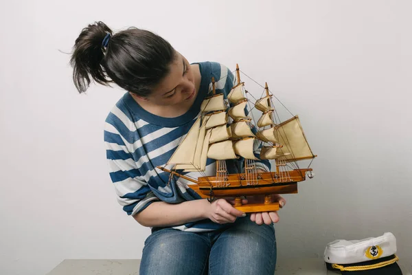 woman with wooden ship model