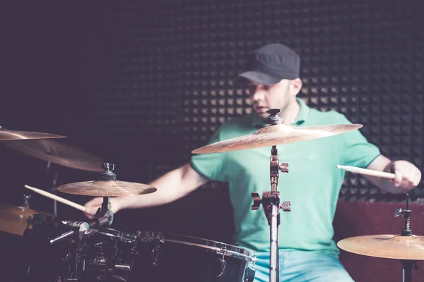 Drummer playing drums at recording studio