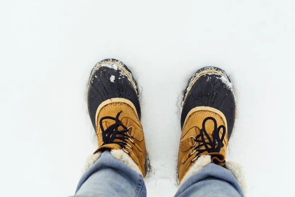 Winter boots in snow, photographer\'s perspective