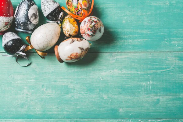 Multicolored Easter eggs on turquoise wooden background