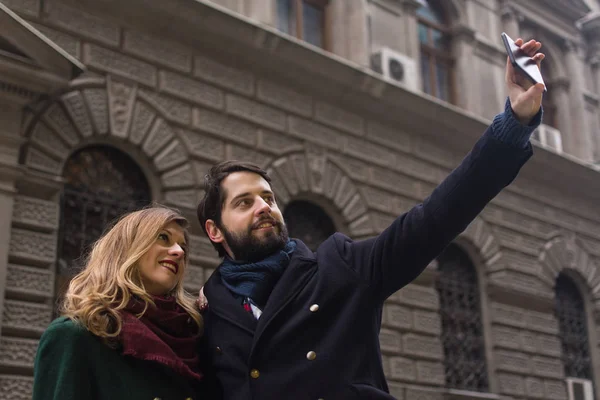 couple at street taking selfie on smartphone