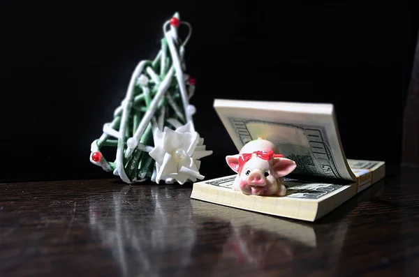 Dolar üzerinde Noel domuzla siyah bir zemin üzerine dekoratif bir Noel ağacı