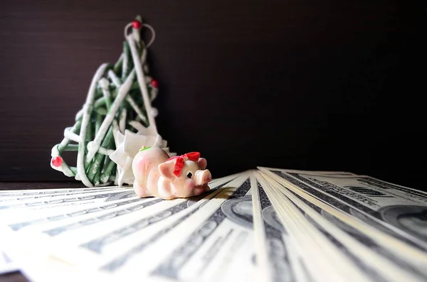 Dolar üzerinde Noel domuzla siyah bir zemin üzerine dekoratif bir Noel ağacı