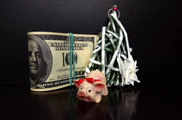 Dolar üzerinde Noel domuzla siyah bir zemin üzerine dekoratif bir Noel ağacı