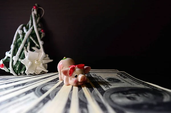 Dolar üzerinde Noel domuzla siyah bir zemin üzerine dekoratif bir Noel ağacı