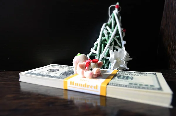 Dolar üzerinde Noel domuzla siyah bir zemin üzerine dekoratif bir Noel ağacı