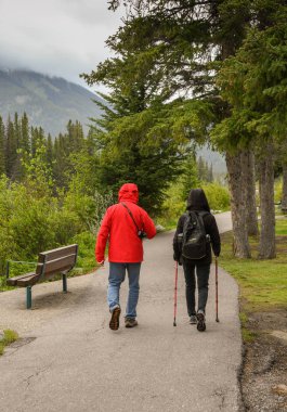 Banff, Ab, Kanada - Haziran 2018: Banff bir patika üzerinde yürüyen iki kişi.
