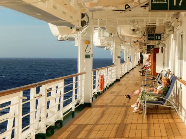 Denizde bir cruise gemi gezinti yerinde oturan insanlar