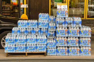 Banff, Ab, Kanada - Haziran 2018: Banff şehir merkezinde bir dükkanının paketleri şişelenmiş su yığılmış