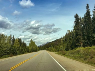 EN ROUTE BANFF TO JASPER, CANADA: Empty highway on the route from Banff to Jasper. clipart