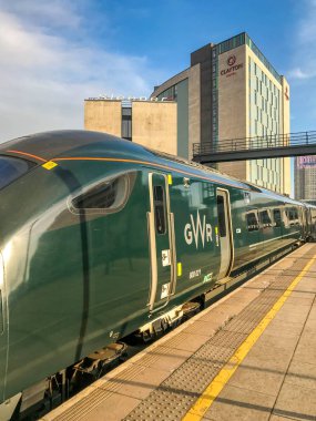 CARDIFF, WALES - DECEMBER 2018: New intercity express train operated by Great Western Railway leaving Cardiff Central station. clipart