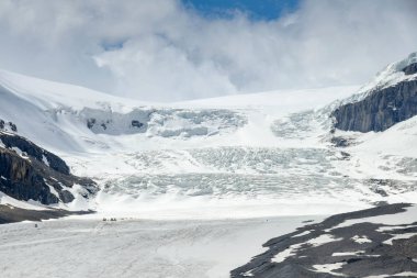 Columbia Icefield, Alberta, Kanada - Haziran 2018: Alberta, Kanada Columbia Icefield Athabasca Buzulu. Ölçeğin görülen alt tarafından buzulda kamyon ve insanlar tarafından sol olabilir.