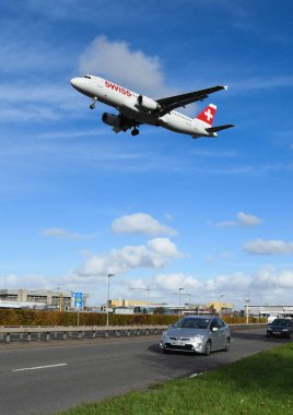 Londra, İngiltere - Kasım 2018: Londra Heathrow Havaalanı üzerindeki trafik A30 bölünmüş geçen arazi gelen İsviçre uçağı.
