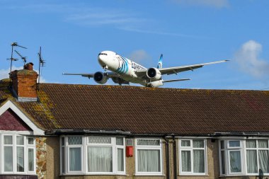 Londra, İngiltere - Kasım 2018: Londra Heathrow havaalanına inmeye rooftops üzerinde alçaktan uçuyordu Egyptair Boeing 777 jet.