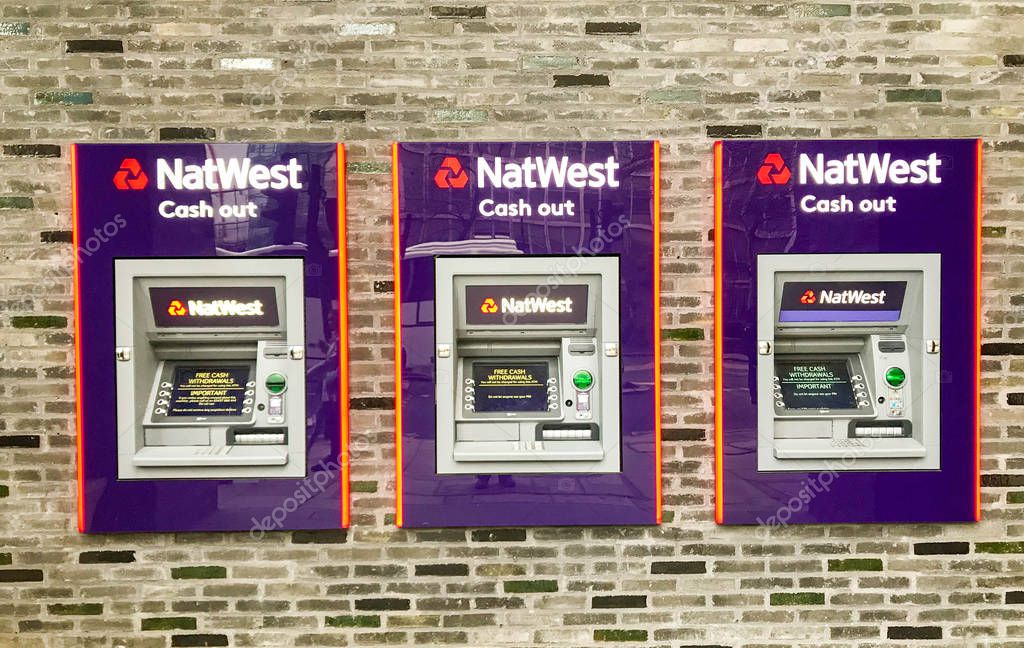 LONDON, ENGLAND - DECEMBER 2018: Trio of cash point machines outide a branch of Natwest bank.