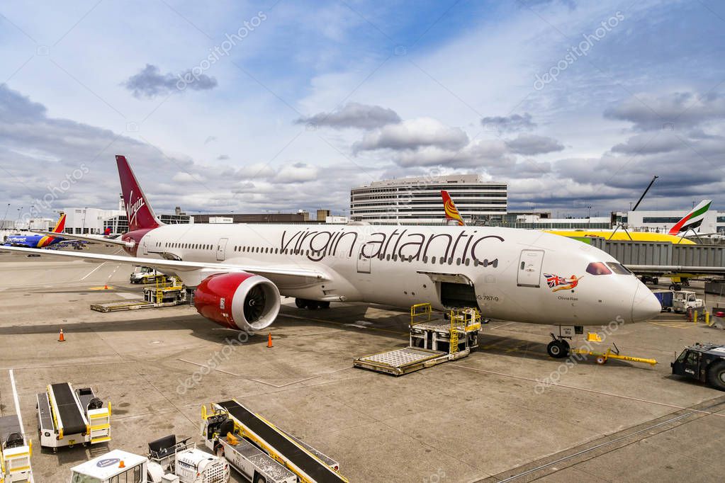 SEATTLE TACOMA AIRPORT, WA, USA - JUNE 2018: Wide angle view of a Virgin Atlantic Boeing 787 Dreamliner jet. The cargo door is open and a pallet loader is parked alongside.