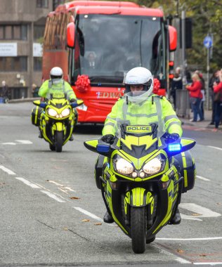 CARDIFF, WALES - Kasım 2018: Güney Galler Polis Teşkilatı 'ndan motosiklet sürücüleri, uluslararası bir maç için Cardiff şehir merkezindeki caddelerde Galler Rugby takımının otobüsüne eşlik ediyor..