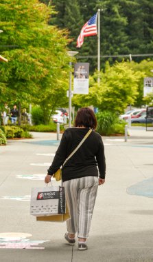 Seattle, Washington State, Amerika Birleşik Devletleri - Haziran 2018: Seattle eteklerinde bir outlet alışveriş sonra kağıt torbalar tutan kişi.