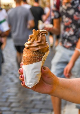 Prag, Çek Cumhuriyeti - Ağustos 2018: tarçın pasta bir huni pasta tutan kişi Prag'da yumuşak hizmet dondurma ile dolu