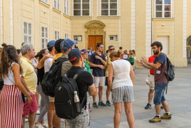 Prague, Çek Cumhuriyeti - Temmuz 2018: tarihi Prag Kalesi ve St Vitas Cathedral turistler bir partiye açıklayan bir tur rehberi.