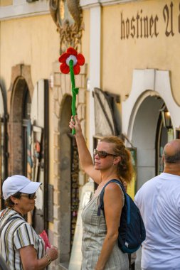 Prague, Çek Cumhuriyeti - Temmuz 2018: Tur parti insanların dikkatini çekmek için bir bayrak kadar parlak renkli çiçek tutan tur rehberi Prag.