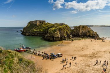 Tenby, Pembrokeshire, Galler - Ağustos 2018: Castle Beach ve St Catherine's Island Tenby, düşük tide, Batı Galler geniş açı görünümü. Küçük gemiyle gezmek sandal geçici bir iskelesi yanında kapalı ziyaretçilerin.