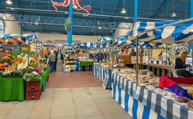 ABERGAVENNY, MONMOUTHSHIRE, WALES - OCTOBER 2018: Wide angle view of stalls in the indoor market hall in Abergavenny town centre. clipart
