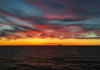 Denizde batımında ufukta cruise gemi