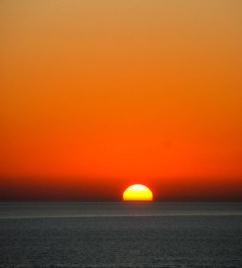 Dominant gökyüzü ile deniz üzerinden günbatımı