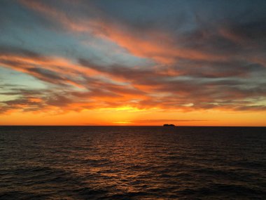 Denizde batımında ufukta cruise gemi