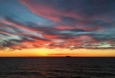 Denizde batımında ufukta cruise gemi