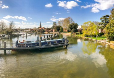 Marlow, Ingiltere-Mart 2019: Marlow 'da Thames Nehri 'nin manzaralı manzarası. Dar bir tekne ön planda hareket ediyor.