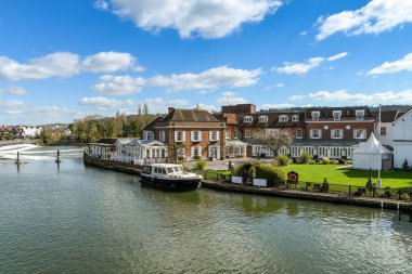 Marlow, İngiltere-Mart 2019: Marlow 'da Thames Nehri üzerindeki Compleat Angler oteli ile birlikte bir motorlu tekne ile demirli.