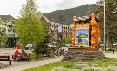 Banff, AB, Kanada-Haziran 2018: Banff şehir merkezinde ahşap oyma ile turist bilgi merkezi dışında Banff Milli Parkı için büyük işaret.