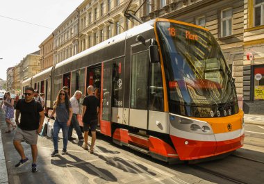Prag, Çek Cumhuriyeti- Ağustos 2018: Prag'ın merkezindeki bir sokakta modern elektrikli tramvaydan inen insanlar 
