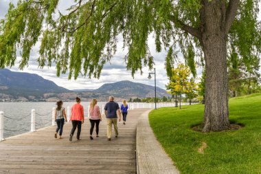 Kelowna, British Columbia, Kanada - Haziran 2018: Kelowna, British Columbia, Kanada'da Okanagan Gölü'nün kenarında yürüyen insanlar.