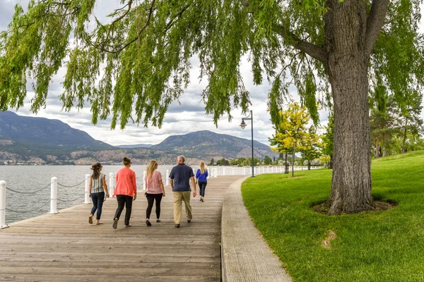 Kelowna, British Columbia, Kanada - Haziran 2018: Kelowna, British Columbia, Kanada'da Okanagan Gölü'nün kenarında yürüyen insanlar.