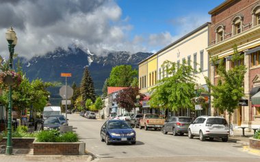 Revelstoke, British Columbia, Kanada - Haziran 2018: Revelstoke şehir merkezinde ağaçlarla çevrili bir sokakta dükkanlar.