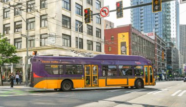 Seattle, Washington State, ABD - Haziran 2018: Sıfır emisyonlu elektrikli tramvay otobüsü Seattle şehir merkezinde bir sokakta köşeyi dönüyor.