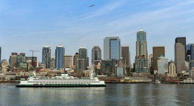 Seattle, Washington State, ABD - Haziran 2018: Puget Sound'u geçtikten sonra gelen büyük bir feribotla Seattle şehir merkezindeki rıhtım ve ofis binalarının şehir manzarası.
