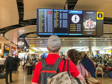 Londra Heathrow Havaalanı - Haziran 2018: Londra Heathrow Havaalanı Terminal 3'te uçuş kalkış ekranLarını kontrol eden kişi.