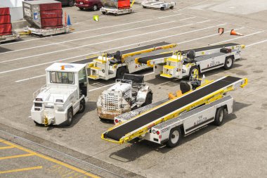 Seattle Tacoma Airport, Wa, USA - Haziran 2018: Seattle Tacoma havaalanında ki önlük üzerine park edilmiş bir bagaj yükleyicisini yansatma, yer taşıma ekipmanları.