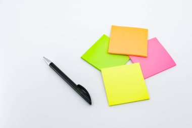 Düz beyaz arka plana karşı yalıtılmış gün içinde kalem ve Not yastıkları.