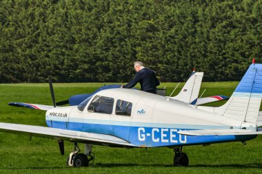 White Waltham, İngiltere - Mart 2019: White Walhtam havaalanındaki West London Aero Club 'da Piper hafif uçağına binen kişi.